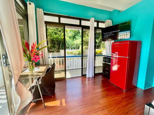 科罗尔Ngermid Oasis - Studio W/ Kitchenette & Pool View的带桌子和窗户的厨房里的红色冰箱