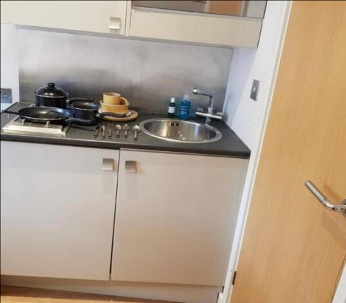 德比Affordable Flats - Derby City Centre的厨房柜台设有水槽和炉灶。