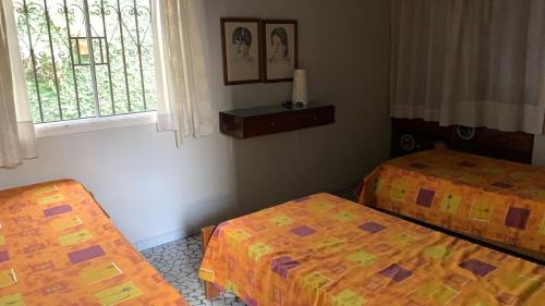 乌巴图巴Casa Itaguá的客房设有两张床和窗户。
