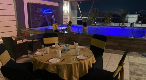 博帕尔Hotel Yuvraj Palace的餐厅的桌子和椅子以及酒吧
