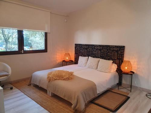 PeralejoAnubha House的一间卧室配有一张带两盏灯的大型白色床。