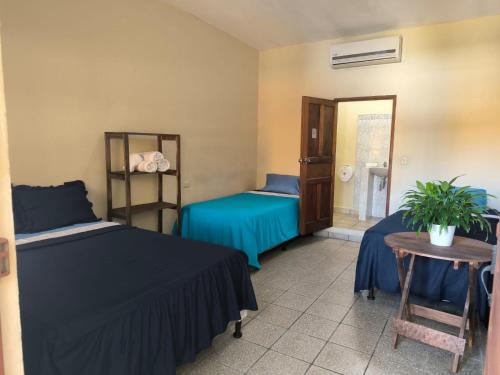 San BenitoHotel y Restaurante Casa Jardines的客房设有两张床、一张桌子和镜子