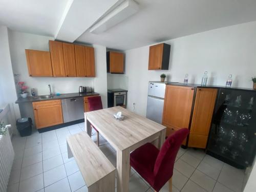 美因茨Mainz Apartment near cetral station的厨房配有木桌和红色椅子