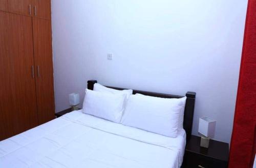 基苏木Motema AirBnB的一间卧室配有带白色床单和枕头的床。
