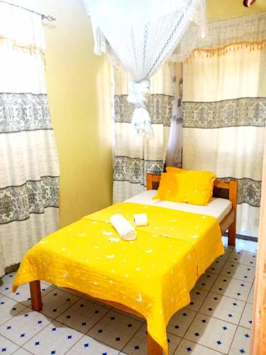 基苏木Motema AirBnB的一间卧室配有一张黄色的床,里面装有电话