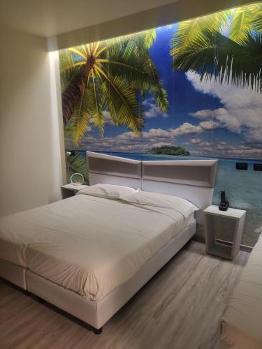 博洛尼亚菲尔拉康体Spa酒店的卧室配有白色的床和棕榈树壁画