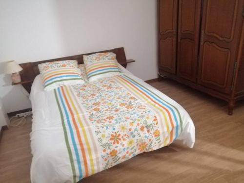 Saint-Julien-Molin-MoletteLa Molette - 4 personnes的床上有色彩缤纷的毯子和枕头