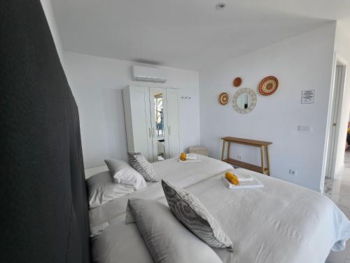 塔扎克蒂Las Norias Apartamentos & Grill的白色卧室配有两张带枕头的床