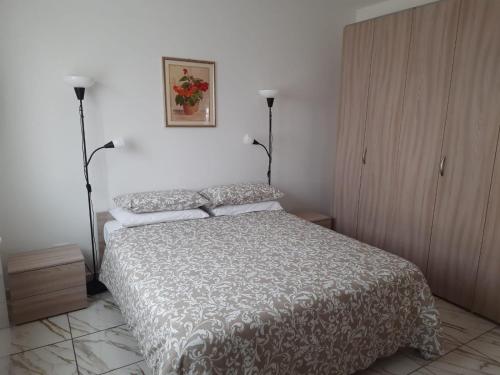 蒙法尔科内Villa Azzurra的卧室配有一张床,墙上挂着一幅画