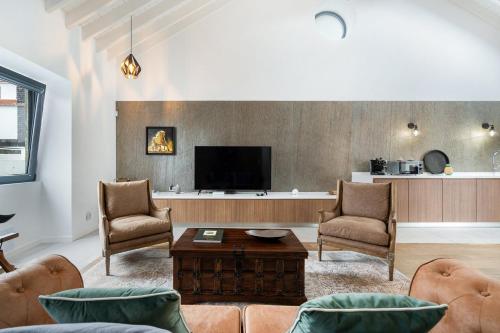 Porto FormosoWelcomeBuddy - São Brás Collection Jacuzzi&Garden的客厅配有沙发、椅子和电视