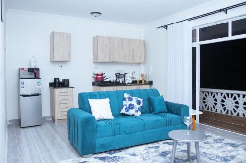 蒙巴萨Kezmo Siloam Paradise的一间带蓝色沙发的客厅和一间厨房