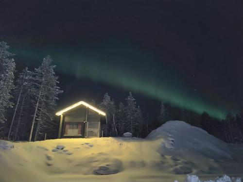 罗瓦涅米Lapland Aurora cabin的夜晚雪中光秃秃的小屋