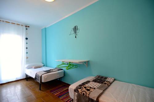 莱斯卡拉Apartamentos Puig Sureda的蓝色的客房配有一张床和一张桌子