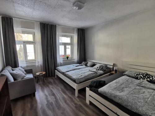 亚希莫夫Apartmány Cipriani的一间卧室配有两张床、一张沙发和一把椅子