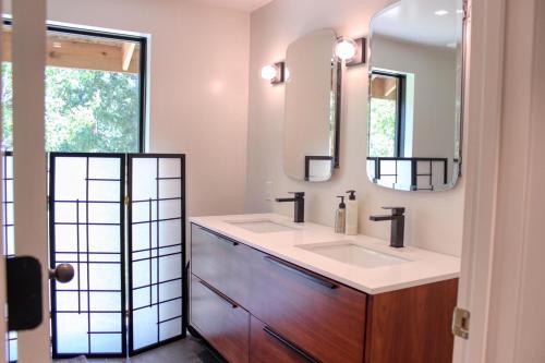 黑利Charming Scandinavian Modern Riverfront Fishhouse的浴室设有2个水槽和2面镜子