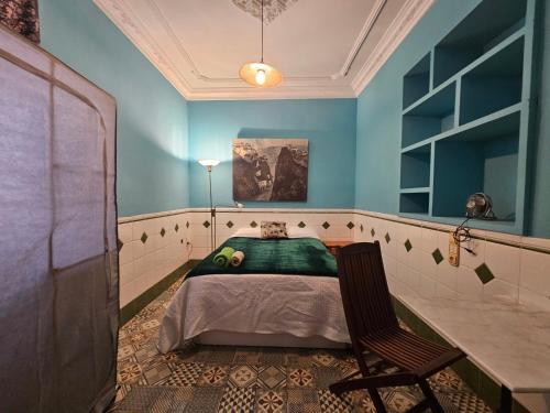 甘迪亚Fabrica de Sueños的一间卧室配有一张床和一把椅子