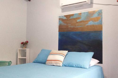 El PorvenirCasa Pico Bonito的卧室配有一张蓝色的床,墙上挂着一幅画