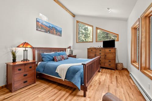 DumontMill Creek Cabin - Dumont的一间卧室配有一张床、梳妆台和电视。