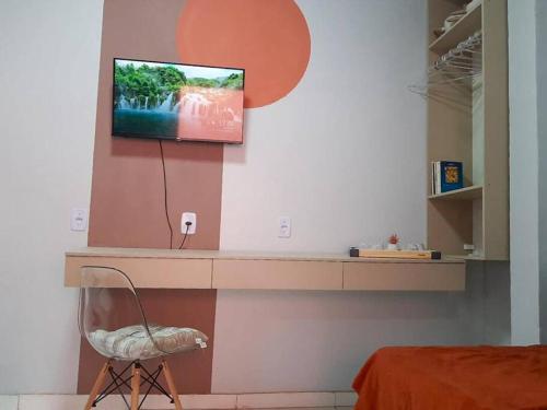 马拉巴Apto com Varanda Próximo da Orla的一间房间,墙上配有电视和椅子