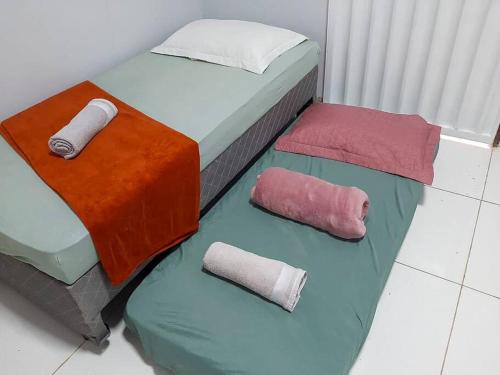 马拉巴Apto com Varanda Próximo da Orla的两张带不同颜色床单和枕头的床
