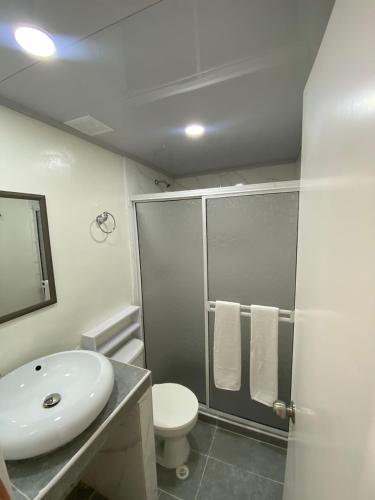 圣安德烈斯Holiday Sai Hotel的浴室配有卫生间、盥洗盆和淋浴。