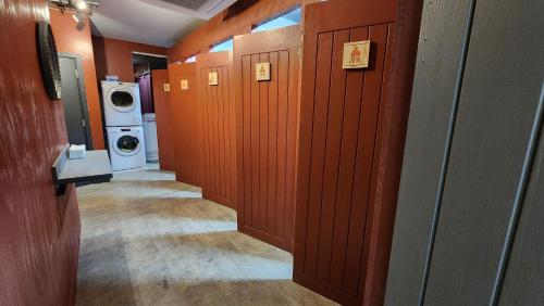 伦敦Komo Pod Hotel的走廊上的浴室设有洗衣机和烘干机