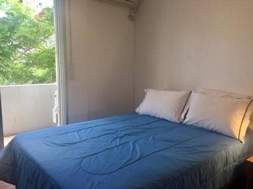 蒙得维的亚Artistes du Monde的一张带蓝色毯子和窗户的床