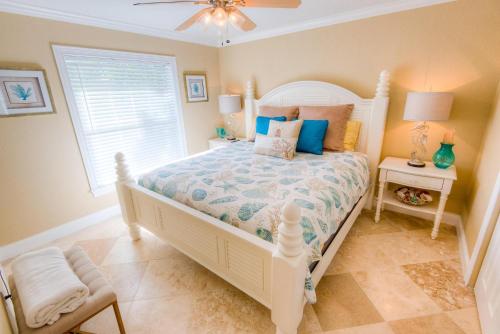 霍姆斯海滩Pineapple Key的卧室配有白色的床和窗户。