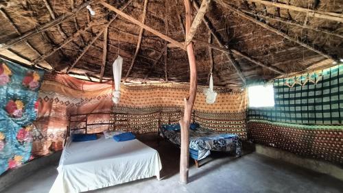 KachiouaneCampement Kaymba Lodge的稻草帐篷内的一个床位