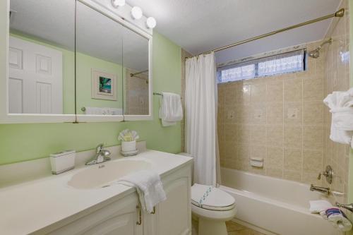 布雷登顿海滩Runaway Bay的浴室配有盥洗盆、卫生间和浴缸。