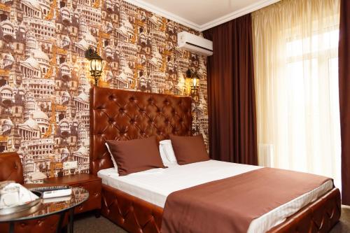 沃罗涅什Hotel Marton Business的一间卧室设有一张大床和一面墙,