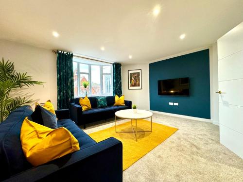伯恩茅斯Amazing Large 3 Bedroom Apartment - Sleeps 8!的客厅配有蓝色的沙发和桌子
