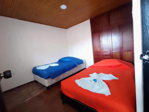 通哈Apartamentos Casa MJ Tunja的红色和蓝色的客房内的两张床