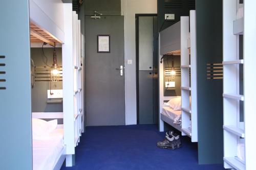 拉普拉涅ho36 La Plagne的走廊上设有两张床,房间铺有蓝色地毯