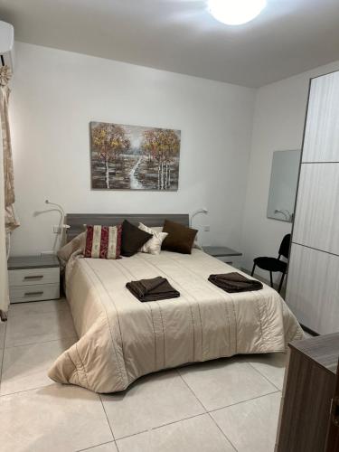 艾因西莱姆Orchidea Appartment的一间卧室配有一张大床和两条毛巾