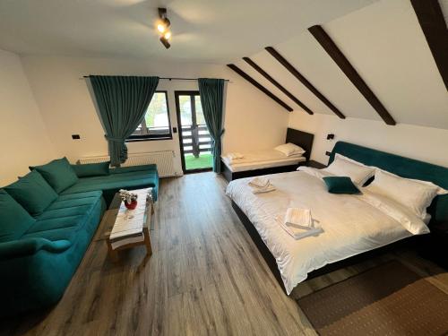 博尔沙Pensiunea Lacul Arșiței的一间卧室配有一张大床和一张绿色沙发