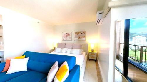 檀香山S&N Lux Suite-Free Parking-King Bed-Kitchen-WiFi的配有床和蓝色沙发的房间