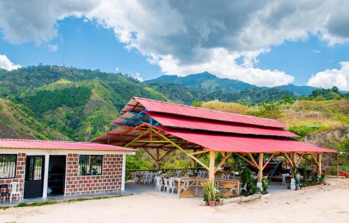 GiganteLos Nevados Ecolodge的餐厅拥有红色屋顶,以群山为背景
