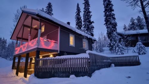 耶姆赛Villa Magnolia 1 Himos的雪中的房子,上面有圣诞灯