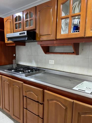 波哥大Way Maker sede 2的厨房配有木制橱柜和炉灶烤箱。