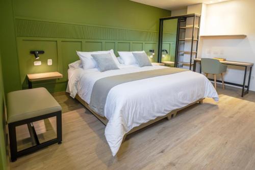 帕斯托Siete Balcones Hotel y Coworking的卧室设有一张白色大床和绿色的墙壁