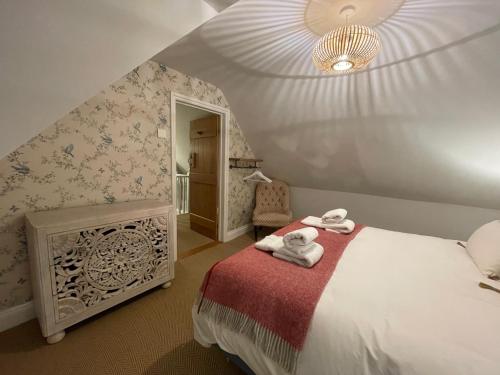 亨利昂泰晤士Cottage 7 mins from Henley with gated parking的一间卧室配有带毛巾的床