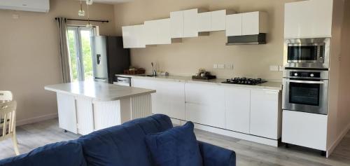La FargueTIE-2 bedroom luxury home的厨房配有白色橱柜和蓝色沙发