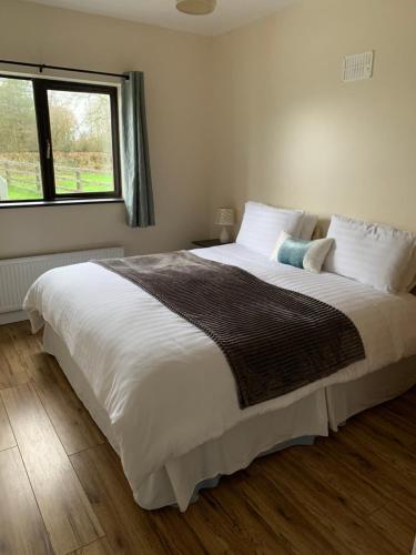 卡文Kits Lodge Crover的卧室配有一张大白色床和窗户