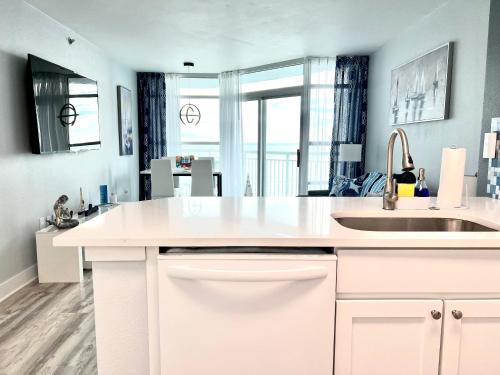 默特尔比奇Oceanfront ,Modern, Luxury, Carolinian Resort的白色的厨房设有水槽和大窗户