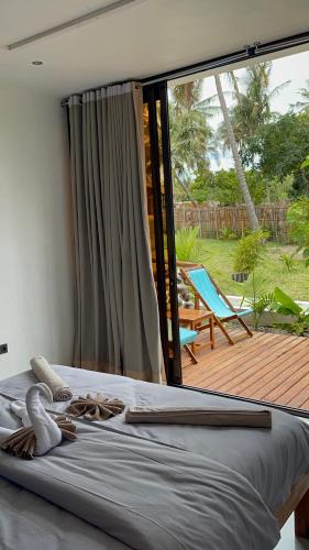 伊尼扬巴内CosyBe Villas的一间卧室设有一张床和一个大型玻璃窗
