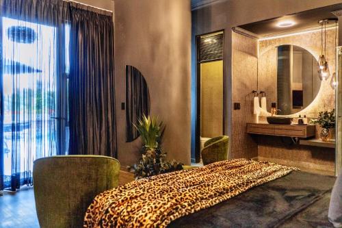 卡利Hotel Osvé Boutique Cali的一间卧室配有床、水槽和镜子
