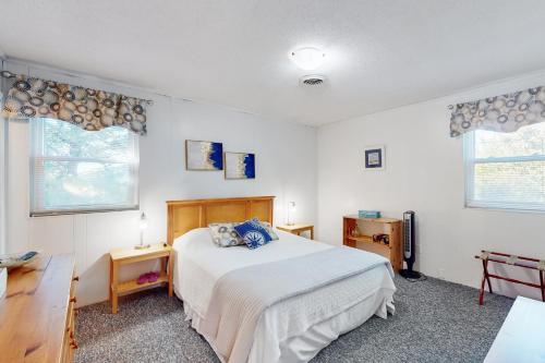 FriscoDolphin Tales的一间卧室配有一张床、一张书桌和两个窗户。