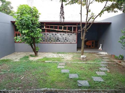 CibuntuHouse in Grand Wisata Bekasi的前面有棵树的建筑