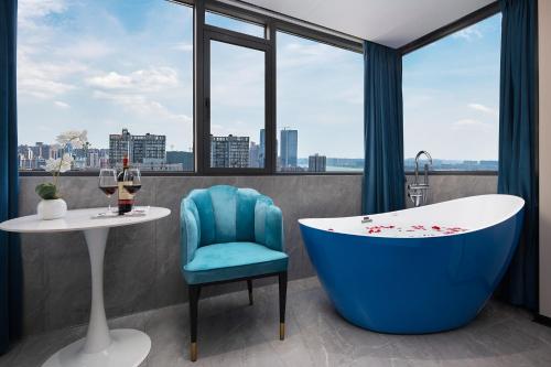长沙沐沐酒店(长沙五一广场地铁站店)的带浴缸、桌子和椅子的浴室